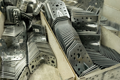 Metal brackets and connectors neatly arranged in storage boxes at a construction supply warehouse ready for distribution to various building projects
