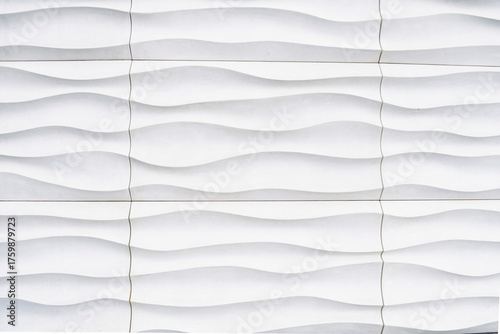 Fototapeta Naklejka Na Ścianę i Meble -  Modern architectural background featuring a seamless pattern of white, wavy, textured wall panels or cladding, creating an abstract, flowing, and minimalist design with subtle shadows.