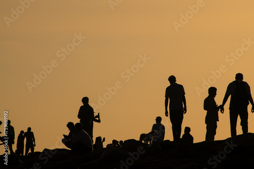 Group of casual people in silhouette watching a sunrise in kanyakumari, India