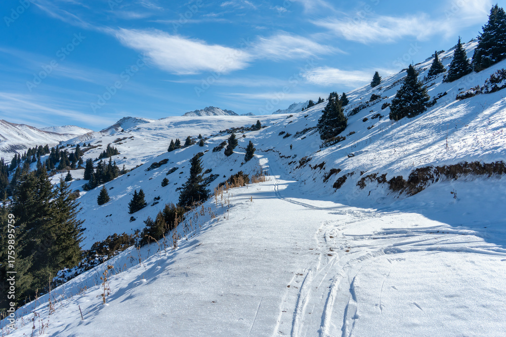 Obraz premium November Snow on Mountain Road Circling Karakol Ski Resort Summit on a Sunny Day.