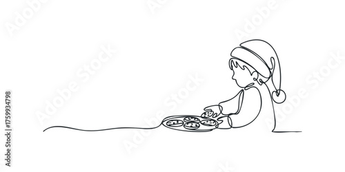 Child wearing a hat holds a plate of cookies