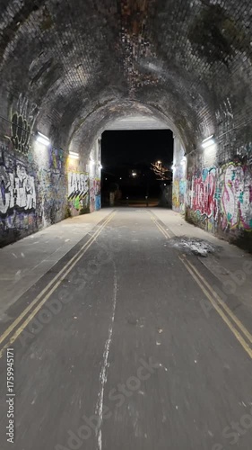 Night walk through an urban graffiti tunnel covered in colorful street art