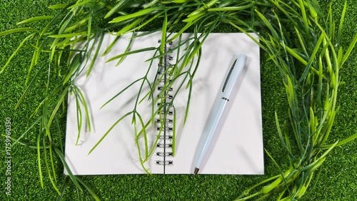 White Notebook and Pen on Green with Fresh Greenery