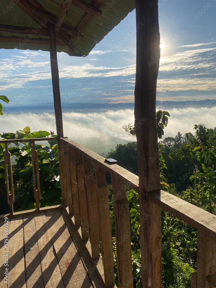 Fototapeta premium Rainforest ecosystem and healthy environment concept.hills with beautiful clouds in the morning. Summer Mountain with green plants and clouds in the sky. wooden hut on Mountain. Texture of green tree