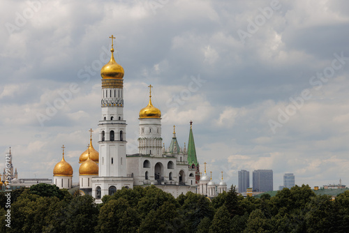 Clouds hover over the Kremlin in Moscow, highlighting its golden domes and stunning architecture on a tranquil day.