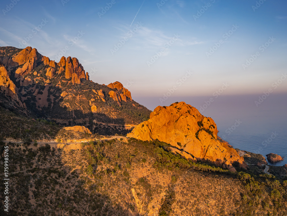 Obraz premium Aerial view of Esterel Mountains and winding coastal road above the blue Mediterranean Sea, French Riviera, France