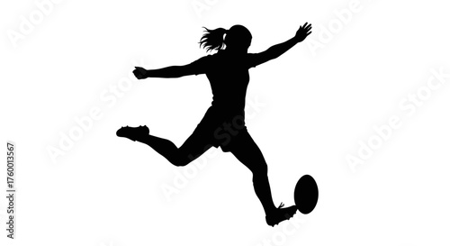 Silhouette of a woman kicking a rugby ball