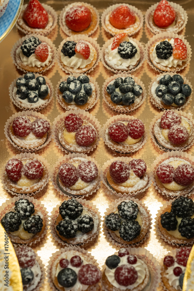 Fototapeta premium Assorted Mini Fruit Tarts with Powdered Sugar Topping