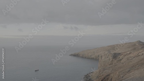 Wide shot of sailboats floating off Madeira Portugal coast under cloudy evening sky (SLOG3)