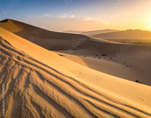 Fototapeta Naklejka Na Ścianę i Meble -  Sunset over rolling sand dunes with mountainous backdrop