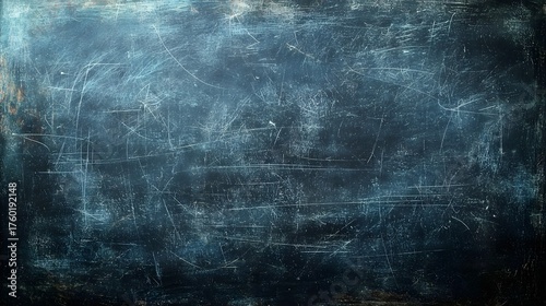 A distressed dark blue blackboard surface covered in numerous white scratches and textured lines abstract grunge background