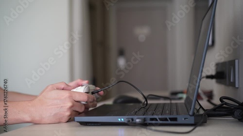 Closeup people hand or gamer holding wired joystick or gaming controller to enjoy playing game on computer notebook or laptop console by joy stick in living room for entertrainment relax on holiday
