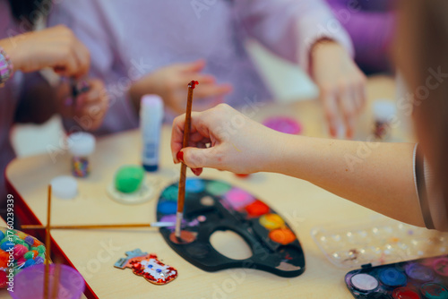 Hands of Adults and kids Doing Arts and Crafts with Watercolor and Glue. People doing artistic projects in a Christmas workshop