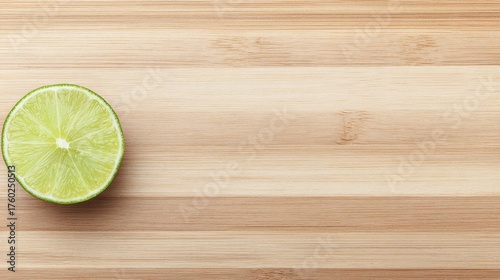 Vibrant fresh green lime slices arranged on rustic wooden cutting board for culinary preparation.