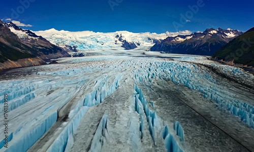 Vast Glacier with Jagged Ice Formations and Snow- Capped Mountains Under Blue Sky nature