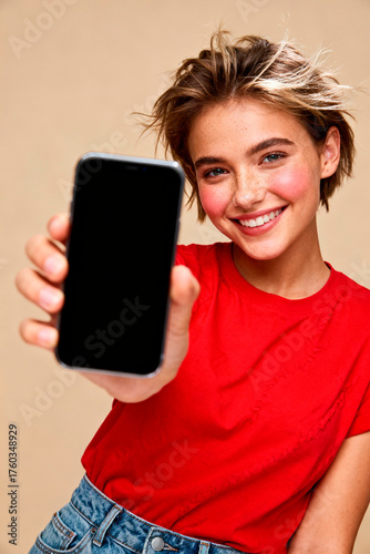 Smiling Caucasian woman holding phone and pointing