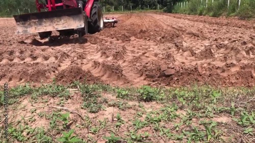 Tractor in Farmland: An agricultural tractor diligently cultivates a field of rich, brown soil, preparing it for planting and nurturing the promise of a bountiful harvest.