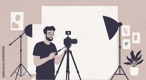 Man with beard setting up camera in photography studio with lights and backdrop, concept for content creation, video production and professional photoshoot