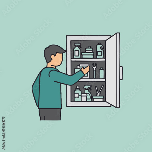A man in a teal shirt reaches into an open white cabinet, selecting an item from shelves stocked with cleaning supplies and essential household tools.