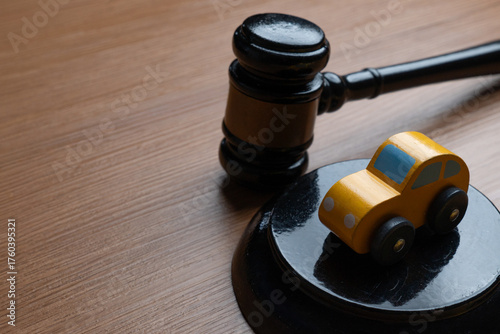 Toy car and a judge’s gavel. Automobile law, insurance claims, legal disputes, traffic court concept.