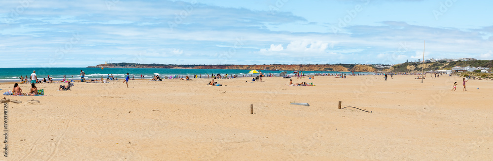 Fototapeta premium Conil, Spain - April 17, 2025: Views of Conil beach in Cadiz, with tourists sunbathing during the Easter holidays in Conil, Spain.
