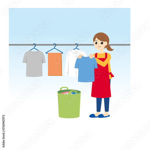 洗濯物を干すエプロンの女性