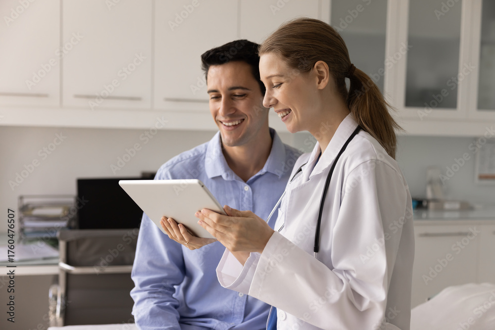 Obraz premium Nurse explains to male patient medical test results on tablet