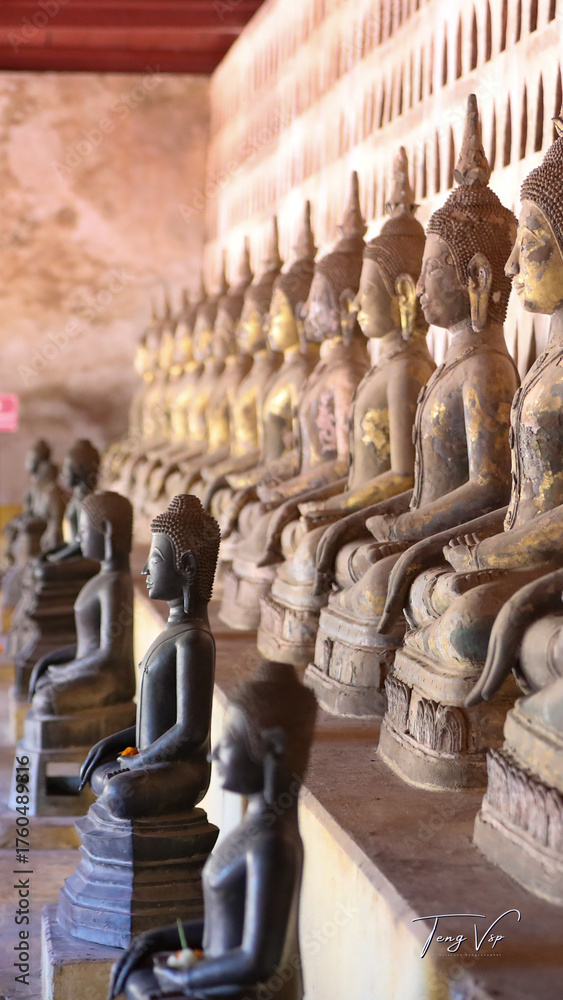 Fototapeta premium Golden ancient Buddha statue in a Lao temple with a serene meditation face, an iconic religious Asian sculpture representing peace and spirituality, Vientiane, Laos