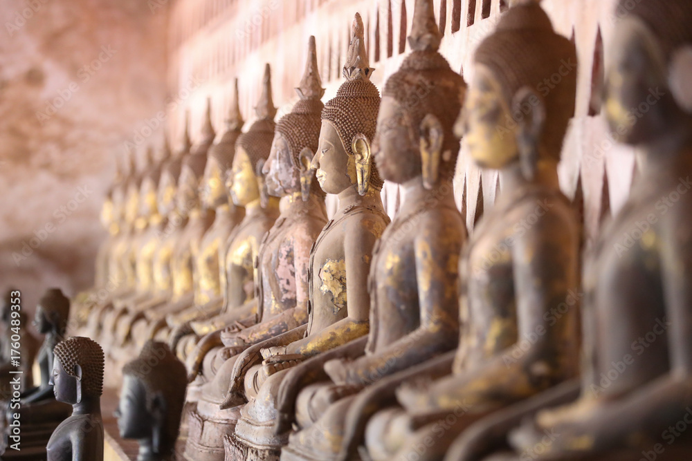 Fototapeta premium Golden ancient Buddha statue in a Lao temple with a serene meditation face, an iconic religious Asian sculpture representing peace and spirituality, Vientiane, Laos