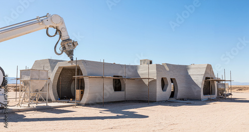 Automated Construction of a Modern House Structure using a Large Robotic 3D Printer on a Desert Development Site