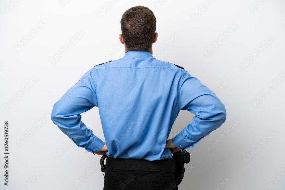 Fototapeta premium Young police caucasian man isolated on white background in back position