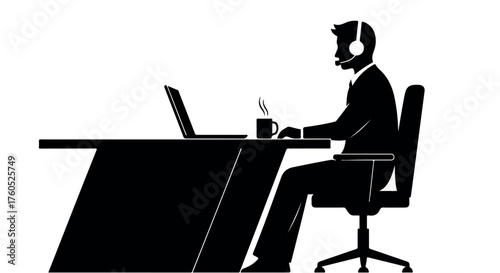 Focused silhouette of a person working at a desk with a laptop and headset
