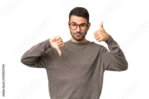 Fotografie Young handsome caucasian man over isolated background making good-bad sign