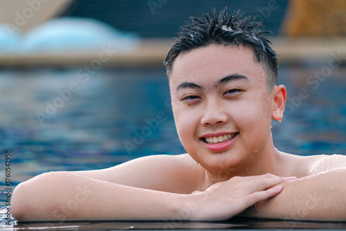 Asian teenage happy and smiling at swimming pool.  Portrait photo style