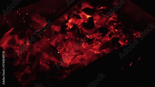 Slow motion closeup of hot charcoal in dark environment