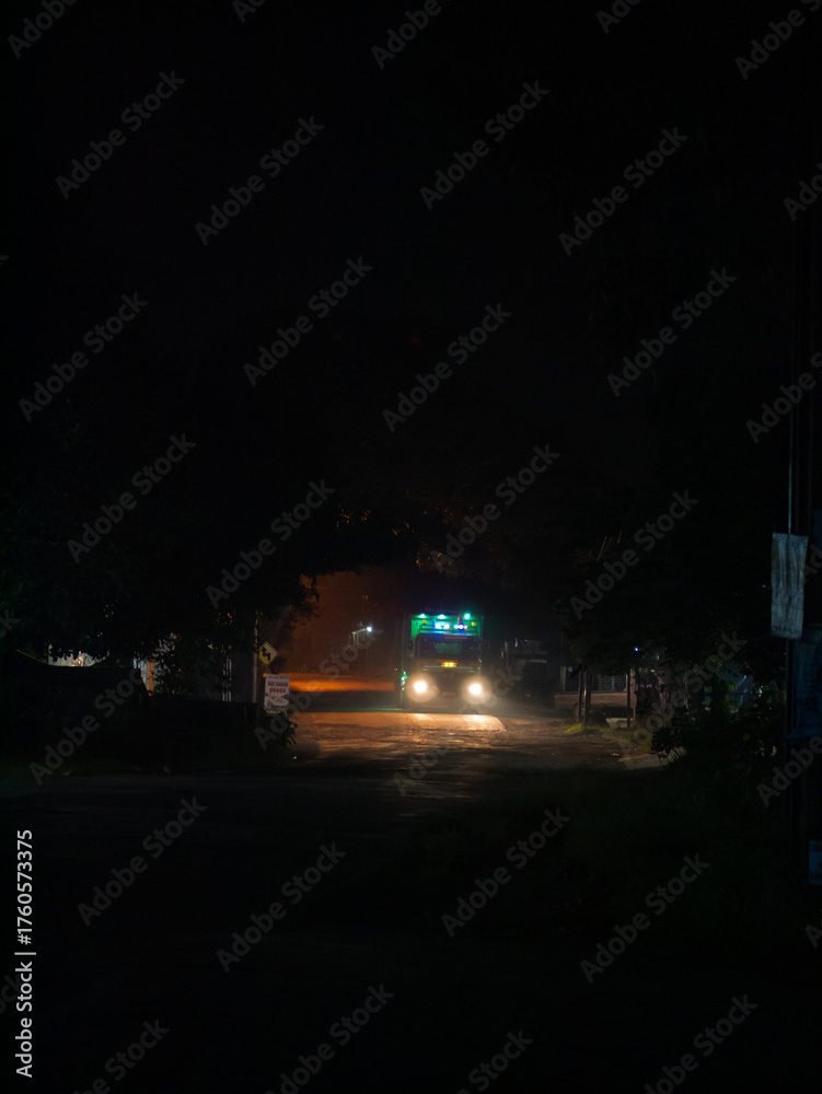 Obraz premium Dimly lit street scene at night with glowing lights and deep shadows