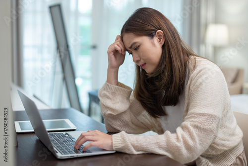 women working on laptop with stressed expression, concept of work pressure, burnout, remote job stress, overwork, or mental fatigue in modern work from home lifestyle.