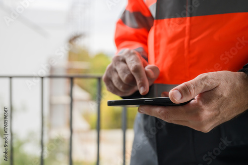 Closeup of hands of civil engineer using smartphone