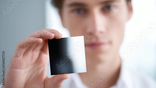 This footage features a young man displaying a black item. It is perfect for projects involving technology and innovation. Explore creativity and intrigue. Generative AI