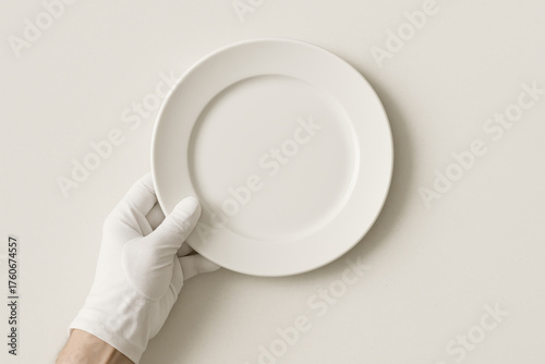 Minimalist Presentation: An isolated hand in a pristine glove delicately holds a clean, empty plate, inviting the viewer to envision the endless culinary possibilities