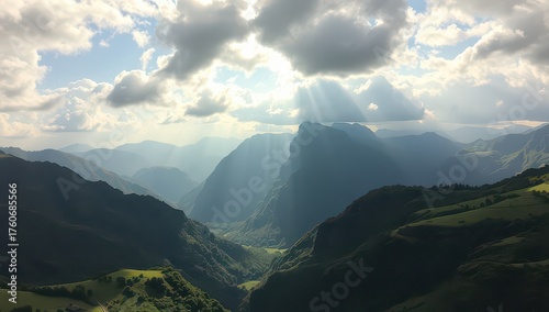 Sunlight streams through clouds over a lush green mountain valley landscape