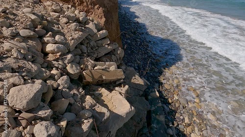 Ocean sea coast shore erosion of soil sand land falling down, roots of trees