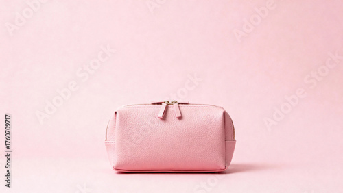Pink cosmetic bag with zipper closure on a soft pink background