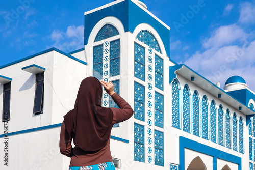 Bild auf Leinwand Young Asian Muslim woman wearing hijab posing in front of Mosque.