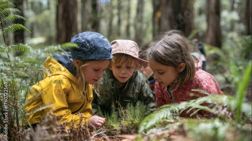 Three children examine plants closely while enjoying a joyful exploration in the lush forest.