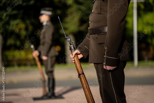 Bild auf Leinwand Latvian honor guards standing in formal uniform holding ceremonial rifles with b