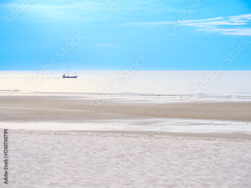 Small Fishing Boat on Bright Blue Sea at Sunrise