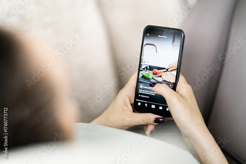 Video on social media. Short reel content in phone. Teen watching viral trend. Woman scrolling clips on mockup platform app in smartphone in hand.