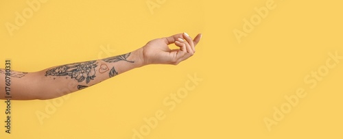 Arm of tattooed young woman...