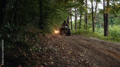 forest ride, trail ride, nature trail. Driving along rugged trail in heart of dense forest, group experiences exhilarating outdoor adventure on ATVs.